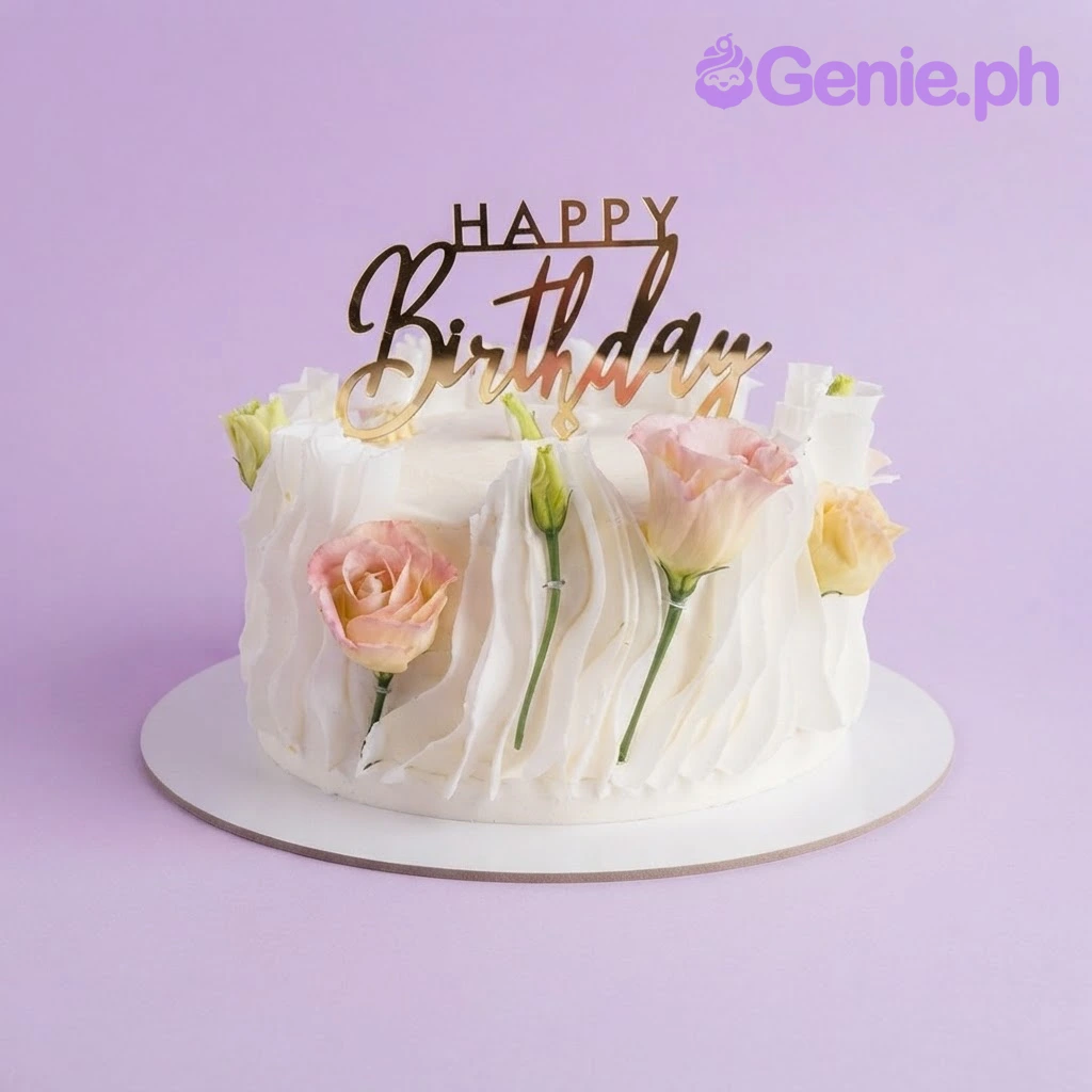 Birthday White Cake White 1 tier birthday cake with smooth icing, a gold acrylic Happy Birthday topper, and pink and yellow edible roses