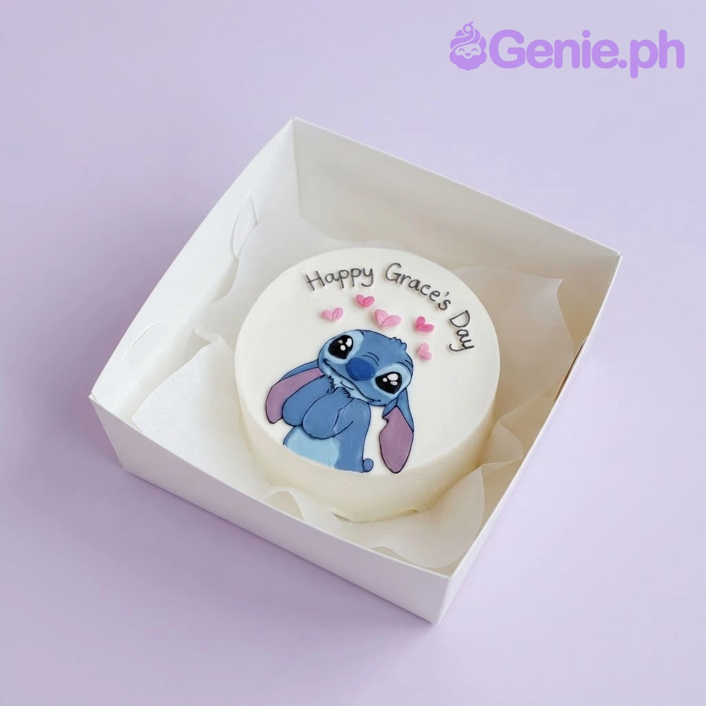 Stitch-Inspired Bento White Cake White bento cake with smooth soft icing, a flat Stitch character topper, and piped black script