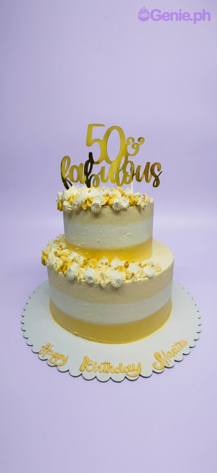 50th Birthday 2-Tier Cake A yellow and white two-tier cake themed for a 50th Birthday, with a gold '50 & Fabulous' topper, piped rosettes, and gold pearls.