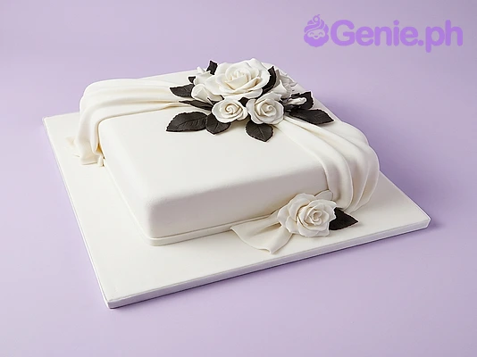 White Floral Cake White square fondant cake with white sugar roses and dark leaves on top and side