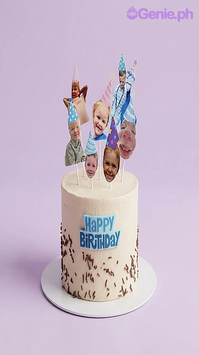 White 1-tier cake with soft icing, chocolate sprinkles, and multiple printed photo face cutouts wearing party hats