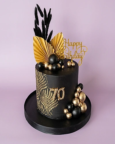 Black single tier cake with gold palm leaf toppers and gold plastic balls