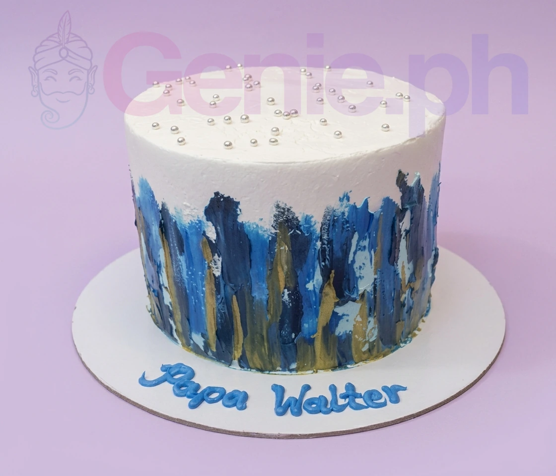 White 1-tier cake with blue and gold palette knife icing textures and silver dragees on top.