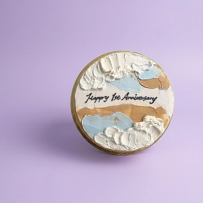 Minimalist 1st anniversary cake with abstract blue and tan palette knife icing on a white base.