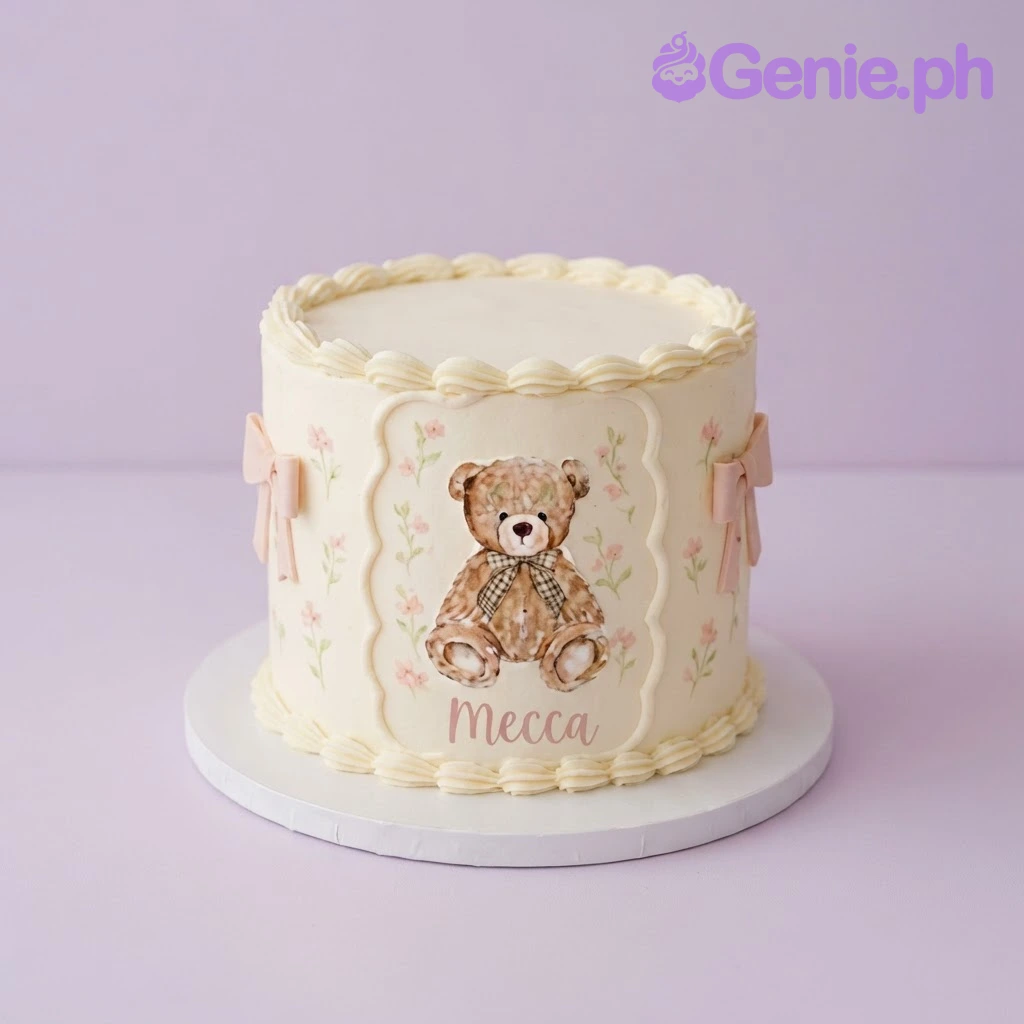 Teddy Bear Ivory Birthday Cake Ivory 1-tier soft icing cake with a printed teddy bear plaque, pink ribbon bows, and piped borders