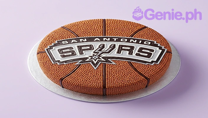 Basketball Spurs Cake One tier orange cake with a San Antonio Spurs logo printout and piped black basketball lines