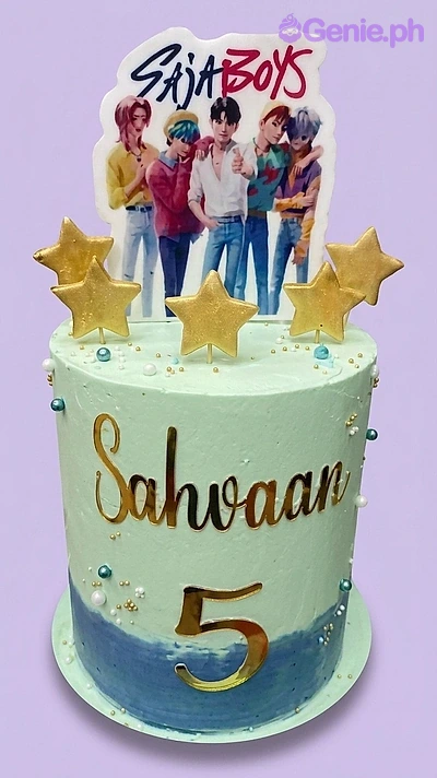 BTS Kpop-Inspired Birthday Cake A light green and blue BTS Saja Boys themed birthday cake, with gold star toppers and a custom name and age.