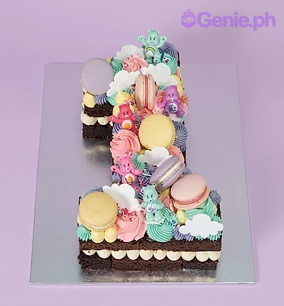 Care Bears Birthday Cake Number one shaped cake decorated with Care Bear figurines, macarons, and colorful icing swirls