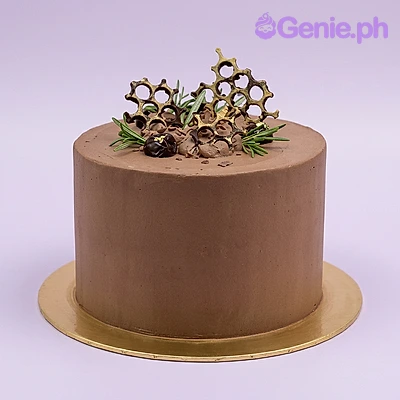 Chocolate Minimalist Brown Cake One tier chocolate minimalist cake with soft brown icing, a chocolate honeycomb structure, and rosemary sprigs