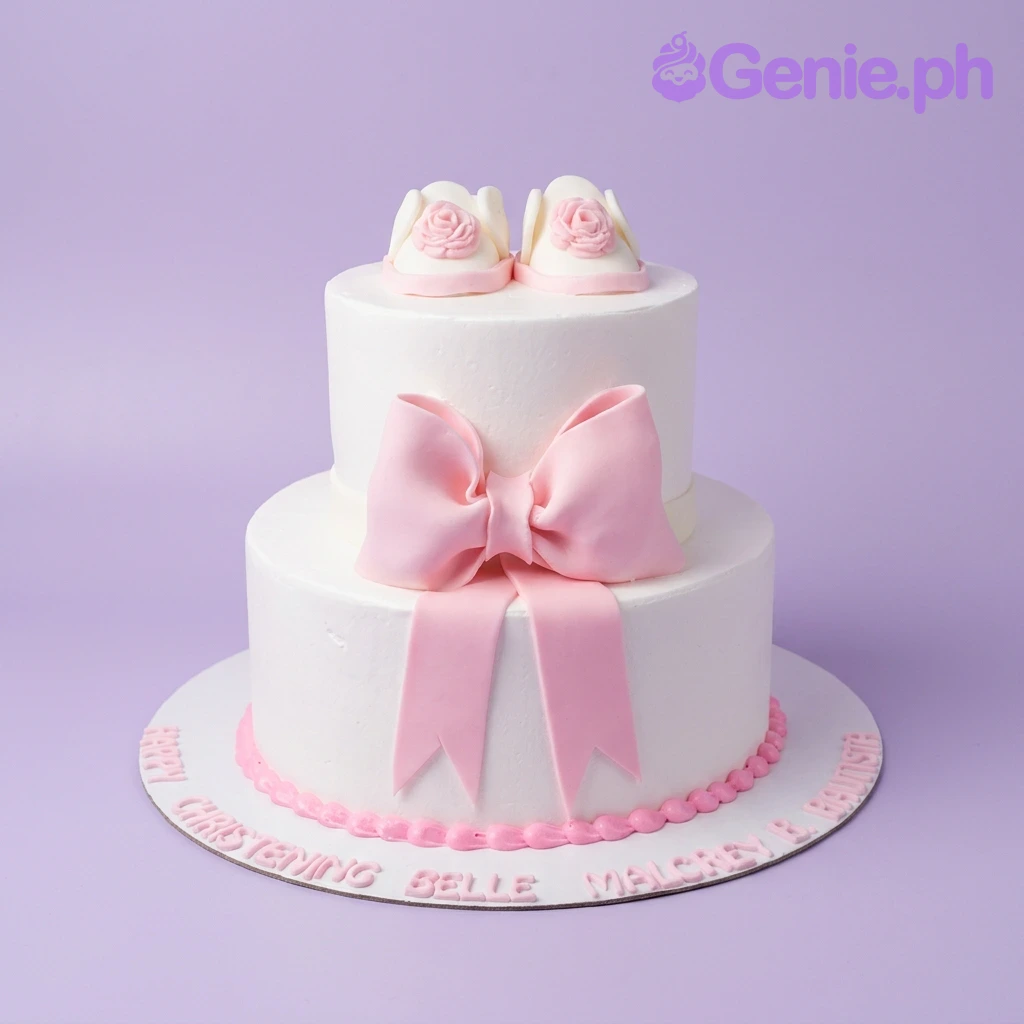 Christening White Bow 2-Tier Cake Two-tier white fondant christening cake with a large pink bow and edible pink baby shoes on top.