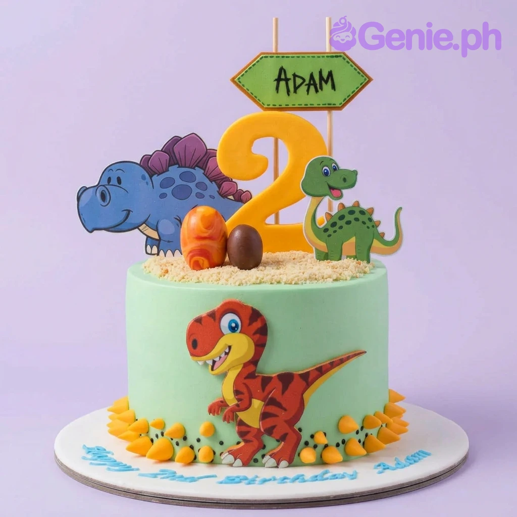 A green 1 Tier dinosaur cake, featuring a yellow number 2, blue, green, and red dinosaur cutouts, and edible eggs.