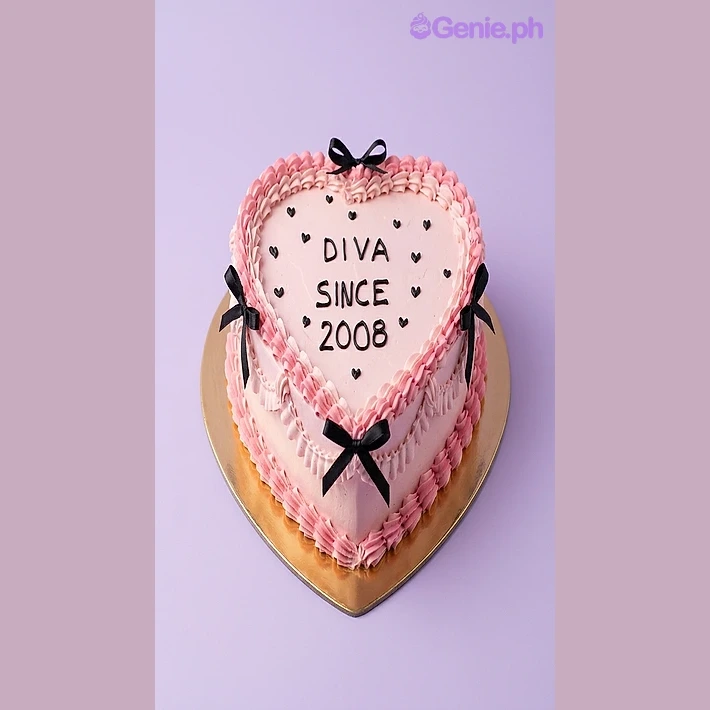 Diva Heart Pink Birthday Cake Pink heart-shaped cake with black piped text and black ribbon bows