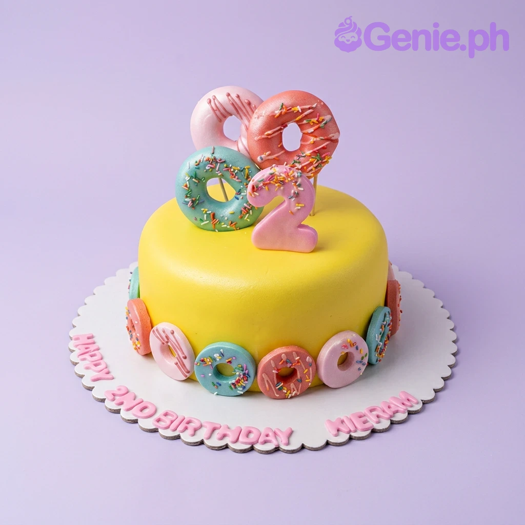 Donut Birthday Orange Cake A yellow 1-tier fondant Donut Birthday cake, featuring a pink number '2' topper, colorful 3D fondant donuts, and personalized text.