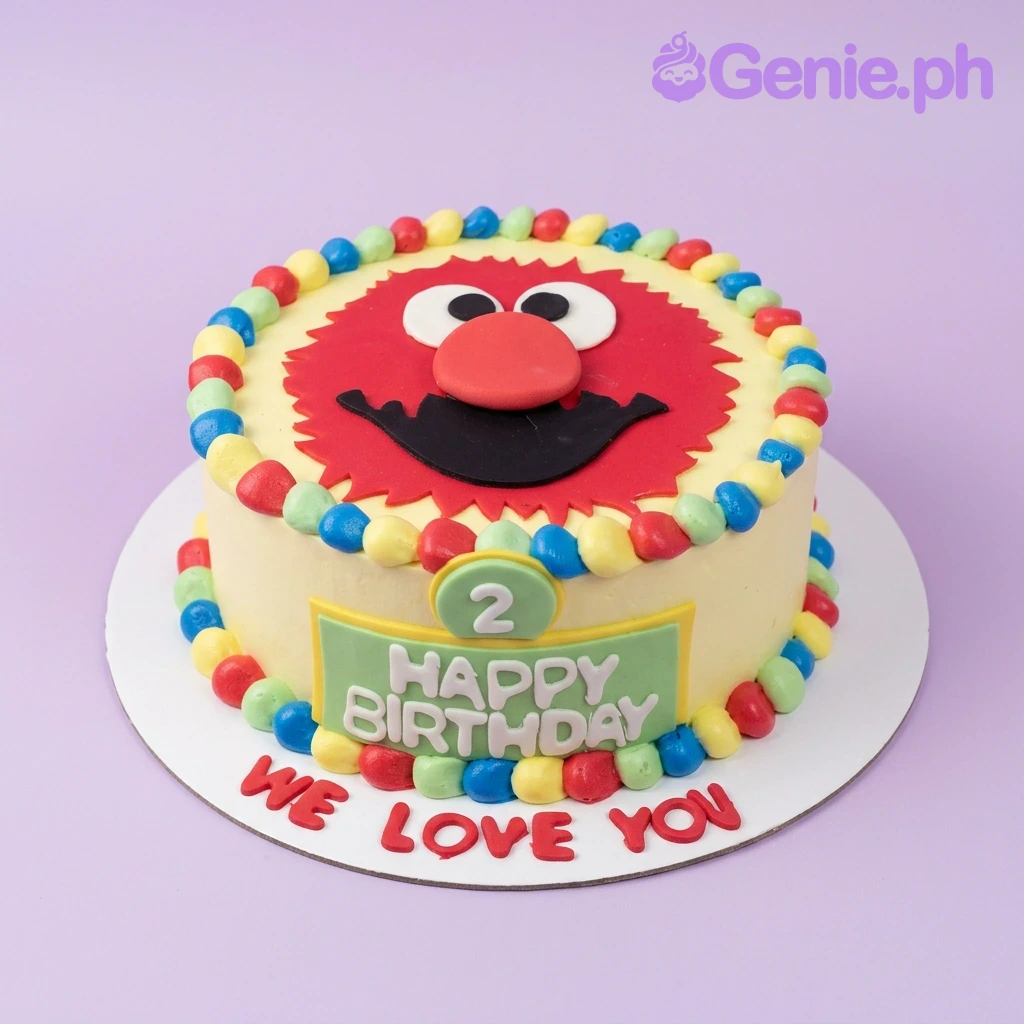 Elmo-Inspired Ivory Birthday Cake A red and light 1-Tier Elmo cake, featuring an Elmo face topper, green '2', colorful border, and a green plaque.