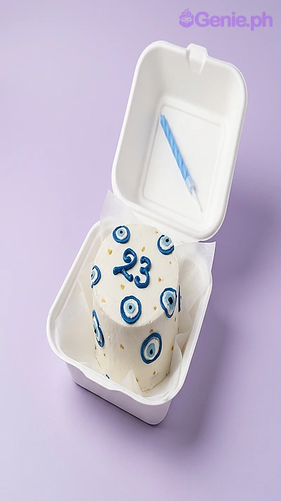 Evil Eye White Bento Cake White bento cake with blue piped evil eye decorations and the number 23 in blue icing