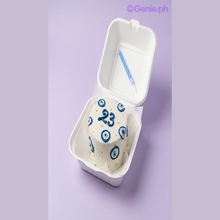 Evil Eye White Bento Cake White bento cake with blue piped evil eye decorations and the number 23 in blue icing