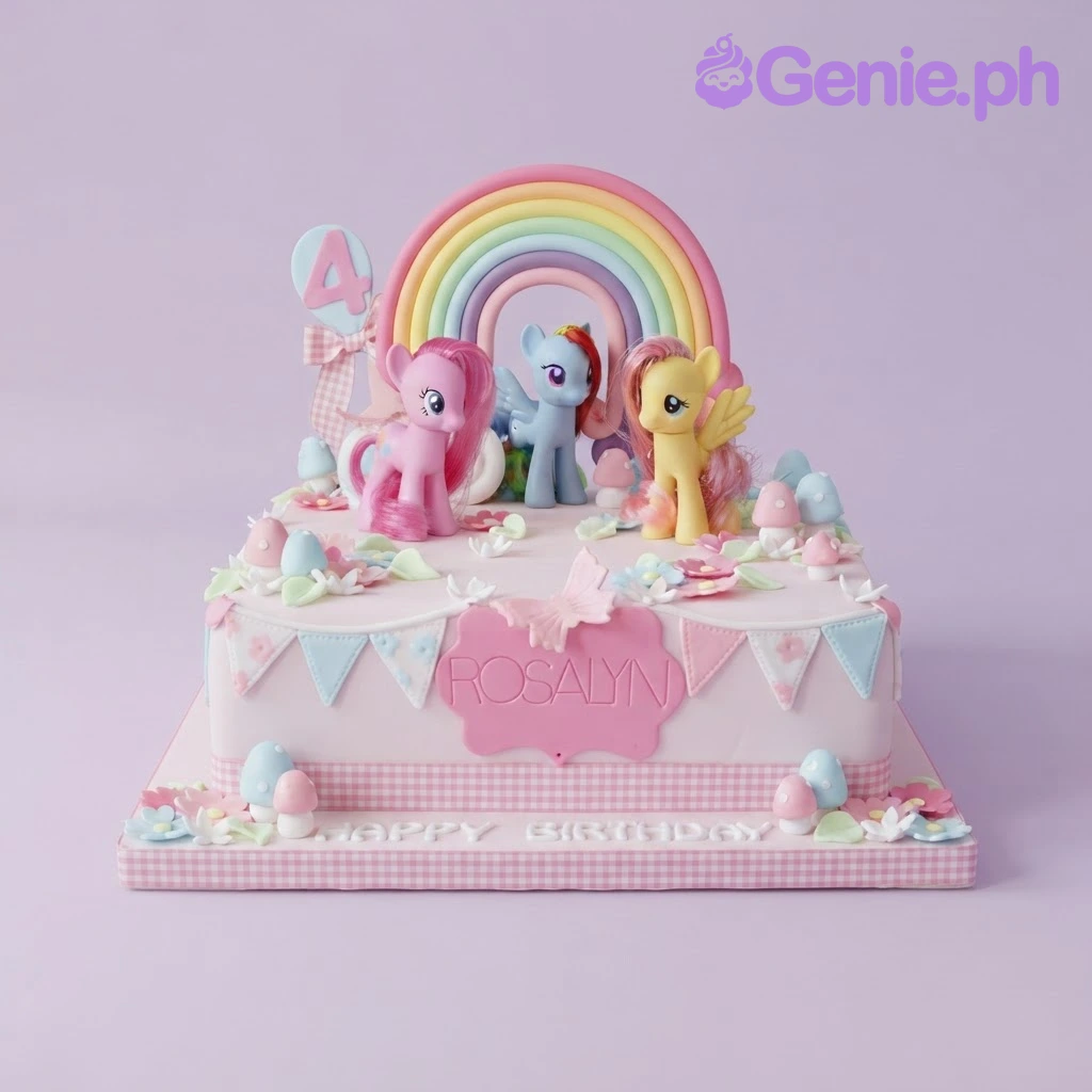My Little Pony-Inspired White Cake Light pink square fondant cake with a rainbow arch, pony figurines, sugar mushrooms, and a name plaque