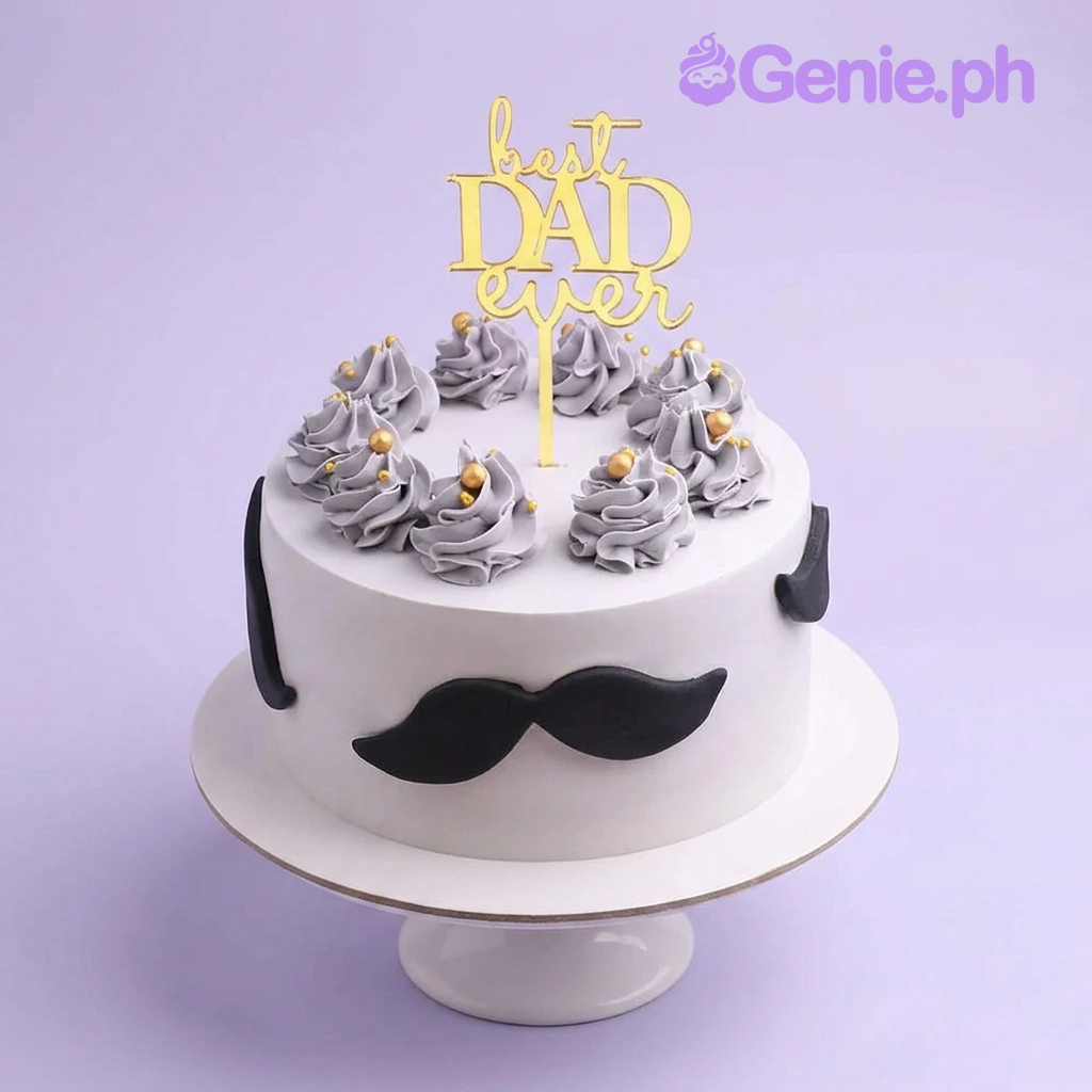 Father's Day White Glitter Cake White minimalist cake for Father's Day featuring a gold Best Dad Ever topper, grey icing swirls with gold pearls, and black fondant mustaches.
