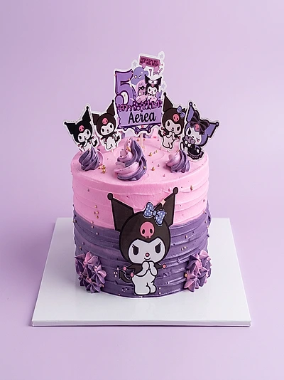 Pink and purple Kuromi birthday cake with character printouts and piped icing swirls