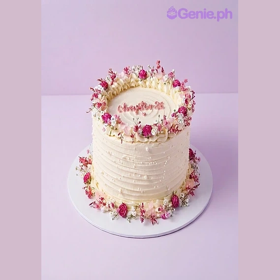 Floral Birthday White Cake White 1-tier birthday cake with pink roses and baby's breath flowers and piped text on top
