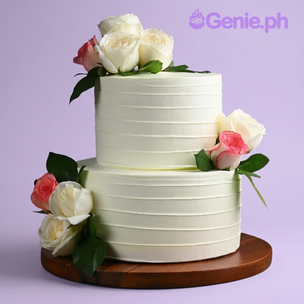 Floral Minimalist White 2-Tier Birthday Cake White 2-tier cake with soft icing texture, decorated with fresh white and pink roses on the top and sides
