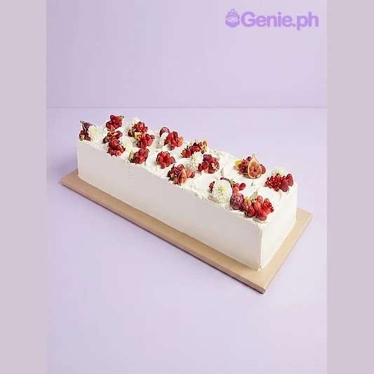 White rectangular cake with soft icing, topped with clusters of fresh red berries and white flowers White rectangular cake with soft icing, topped with clusters of fresh red berries and white flowers