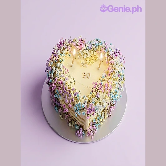 Heart Ivory Floral Birthday Cake Yellow heart-shaped cake with fresh baby's breath flowers and number 50 candle