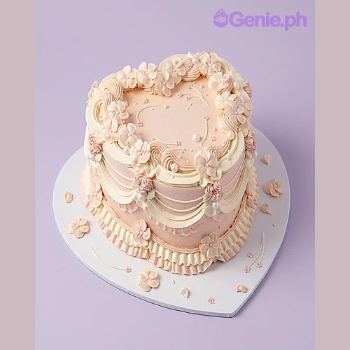 Heart Peach Floral Cake Peach heart-shaped cake with piped icing flowers and edible pearls