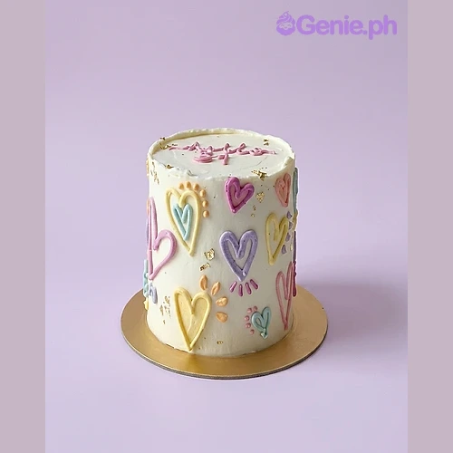 Heart White Cake White single-tier cake with colorful piped icing hearts and gold leaf accents