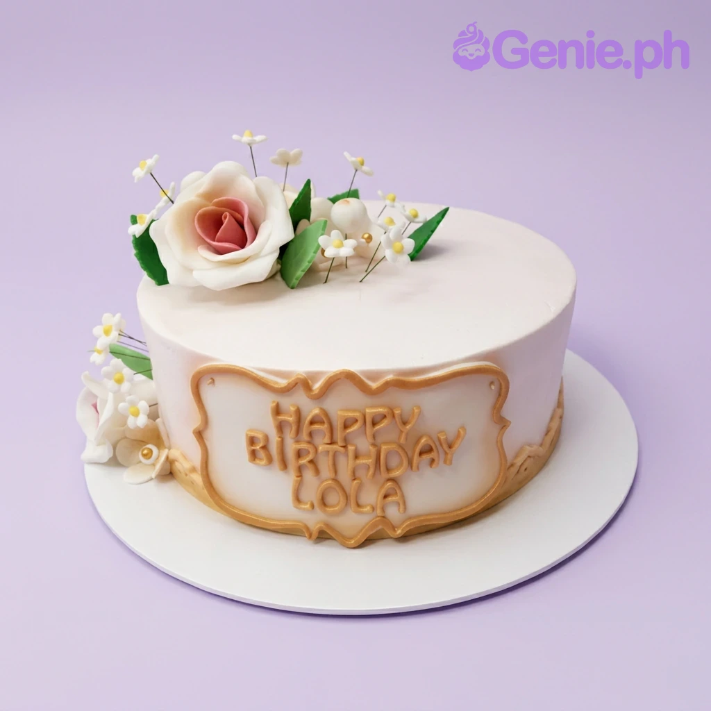Lola Birthday Pink Floral Cake Light pink 1-tier fondant cake, Lola Birthday, with a white/peach sugar rose, white flowers, and gold 'HAPPY BIRTHDAY LOLA'.