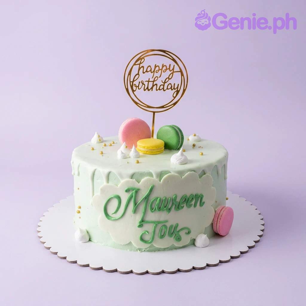 Macaron Birthday Mint Cake A light green 1-tier Macaron Birthday cake, featuring a gold Happy Birthday topper, colorful macarons, white icing dollops, and a name plaque.