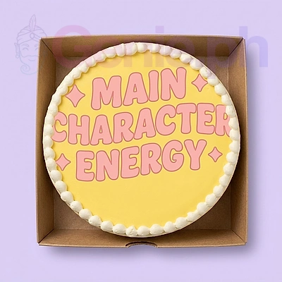 Yellow bento cake with white icing border and pink printed text reading Main Character Energy. Yellow bento cake with white icing border and pink printed text reading Main Character Energy.