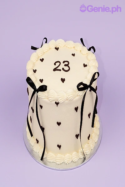 Minimalist Heart Ivory Birthday Cake Ivory 1-tier cake with black satin ribbon bows and small black piped heart decorations