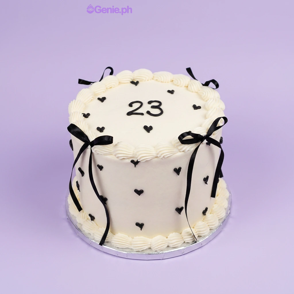Minimalist Heart White Birthday Cake White single-tier cake with black piped hearts and black satin ribbon bows