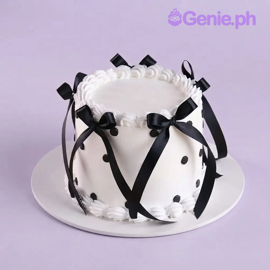 Minimalist Ribbon White Birthday Cake White 1-tier cake with soft icing, black satin ribbon bows, and black fondant polka dots
