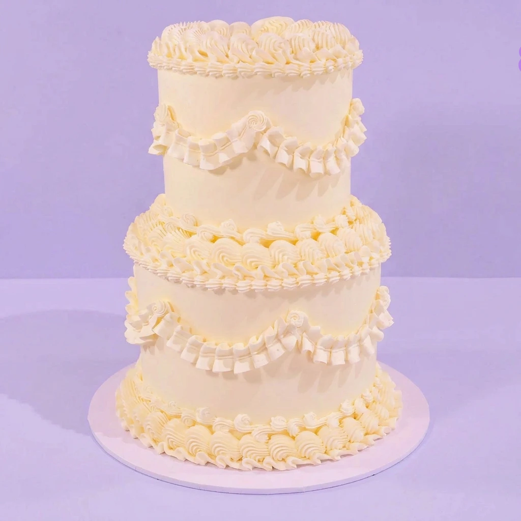 Minimalist White 2-Tier Cake Minimalist White cake design — 2 tier soft icing cake in white — with piped ruffles on sides, and piped borders