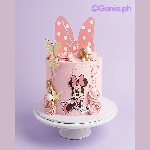 Minnie Mouse-Inspired Pink Bow Birthday Cake Pink 1-tier birthday cake with Minnie Mouse printout topper and character graphic with gold and white spheres