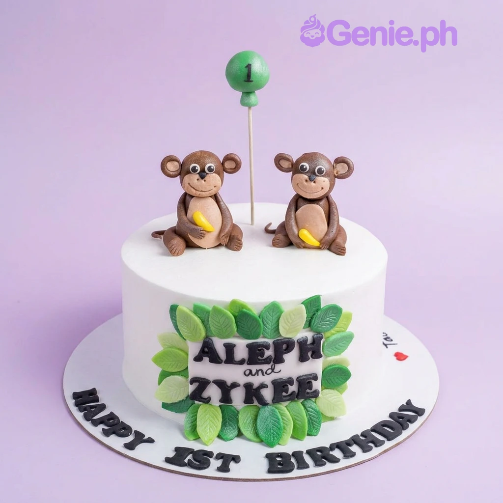 Monkey White Birthday Cake A white 1-tier monkey themed birthday cake with two fondant monkeys holding bananas and green leaf decorations.