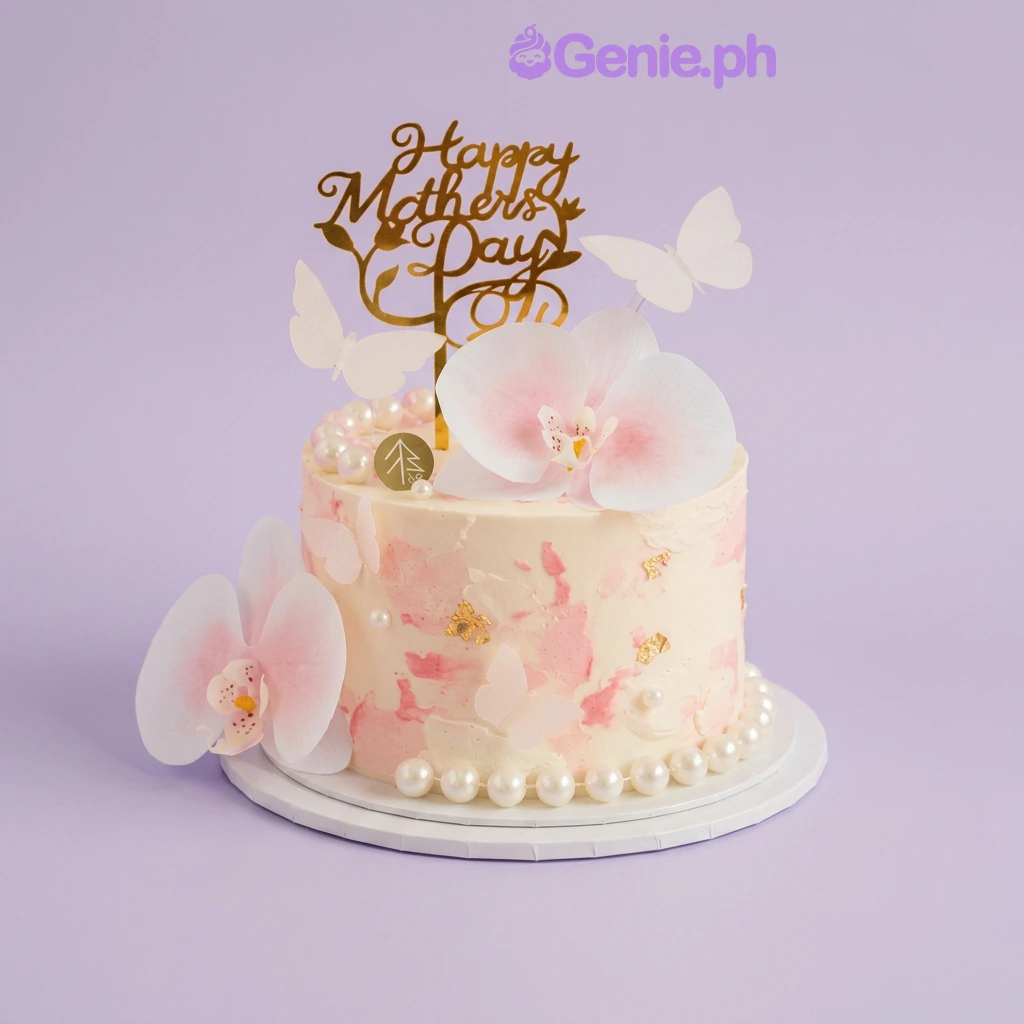 Mother's Day Floral Cake White 1-tier cake with pink watercolor icing, artificial orchids, white butterflies, and a gold Happy Mother's Day topper