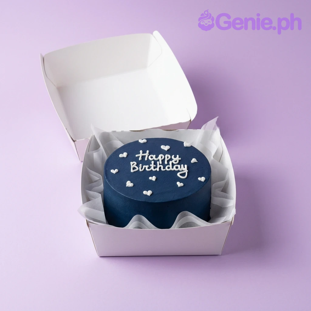 Navy Minimalist Bento Birthday Cake A navy blue and white Bento cake themed around Navy Minimalist, featuring white piped icing hearts and a 'Happy Birthday' message.