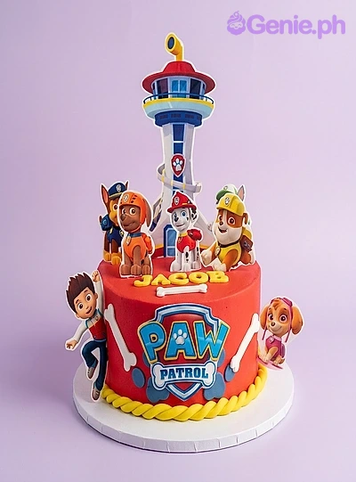 A red 1 Tier cake themed around Paw Patrol, featuring a lookout tower printout, Paw Patrol characters, and edible bone shapes. A red 1 Tier cake themed around Paw Patrol, featuring a lookout tower printout, Paw Patrol characters, and edible bone shapes.