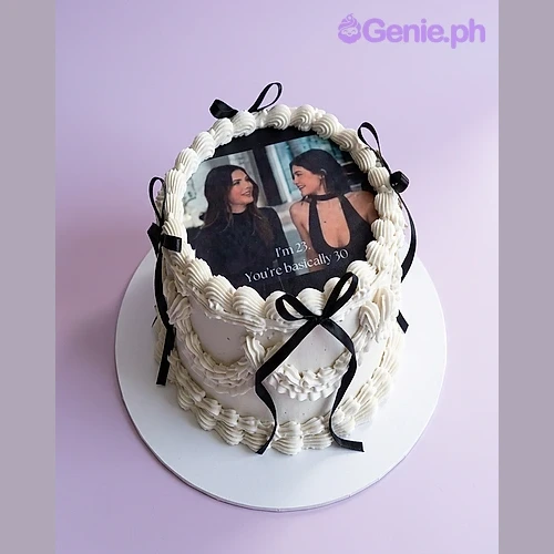 Photo White Cake One tier white soft-iced cake with an edible photo of two women, black satin ribbons, and piped icing borders