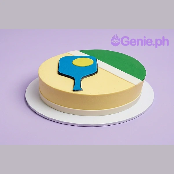 Pickleball Birthday Cake Yellow single tier cake with a blue pickleball paddle and yellow ball design on top