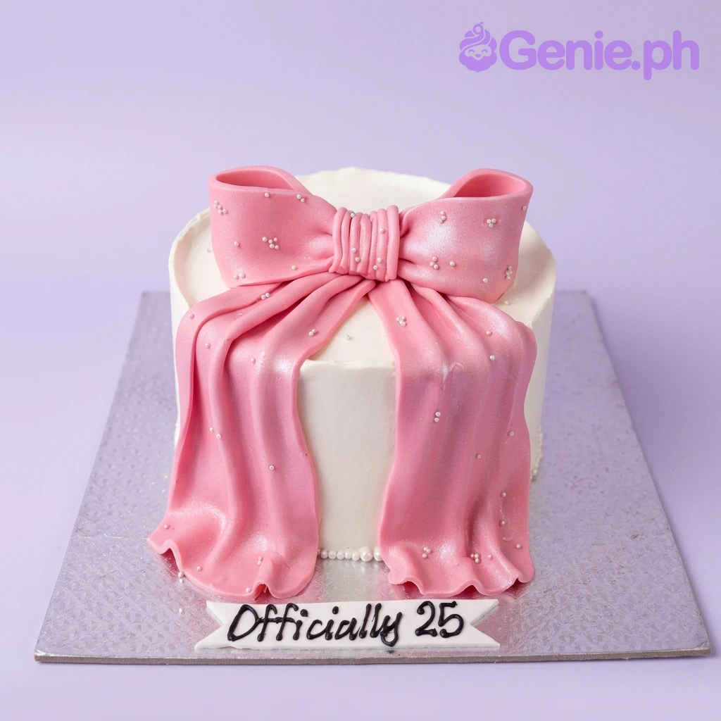 Pink Bow White Birthday Cake A white and pink single tier cake themed around a Pink Bow, featuring a large pink fondant bow and white edible pearls with a text banner.