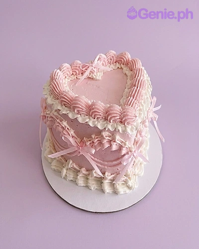 Pink Heart Vintage Coral Cake A pink and white 1-tier cake themed Pink Heart Vintage, featuring pink bows, ruffles, and white icing swags.
