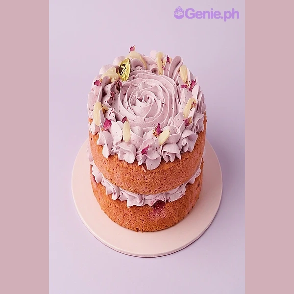Pink naked cake with light pink icing swirls, dried fruit accents, and a slice served on a side plate Pink naked cake with light pink icing swirls, dried fruit accents, and a slice served on a side plate