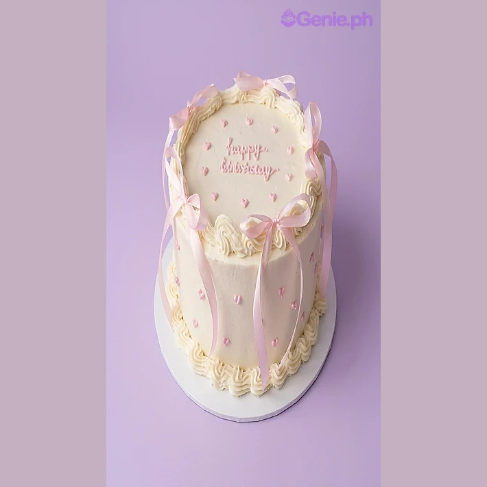 Pink Ribbon White Birthday Cake White single-tier birthday cake with pink satin ribbons and piped pink hearts