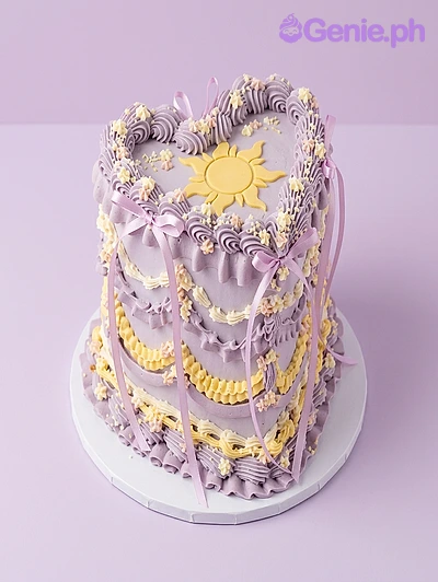 Rapunzel-Inspired Heart Lavender Birthday Cake Lavender heart-shaped cake with Rapunzel sun symbol and satin ribbons