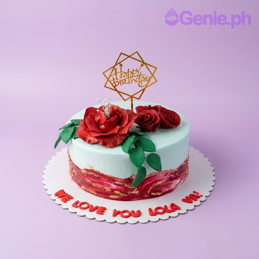Red Rose Birthday Floral Cake A light blue 1-tier cake themed Red Rose Birthday, with a gold Happy Birthday topper, red roses, and green leaves.