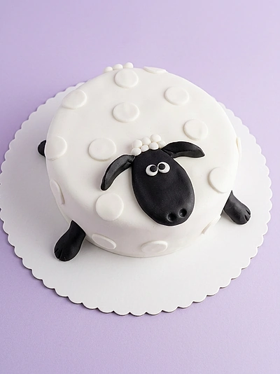 Sheep White Birthday Cake A white 1 Tier Fondant cake themed around Sheep, featuring a black sheep face, black legs, and white wool texture.
